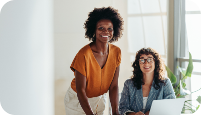 Smiling coworkers looking at the the camera while working in a modern office