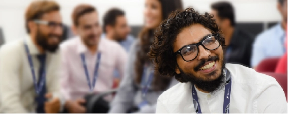 Smiling professional listening during a team discussion in an office setting.