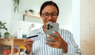 Woman managing her banking needs conveniently from home using a smartphone.