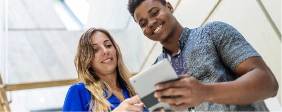 Colleagues reviewing information together on a tablet in an office setting.