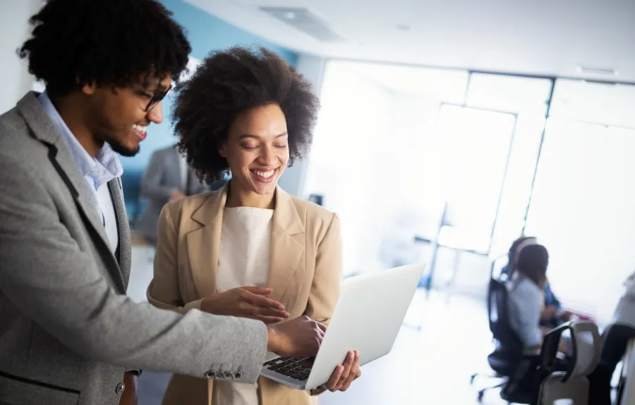 Two African professionals exchanging business strategies in an office.