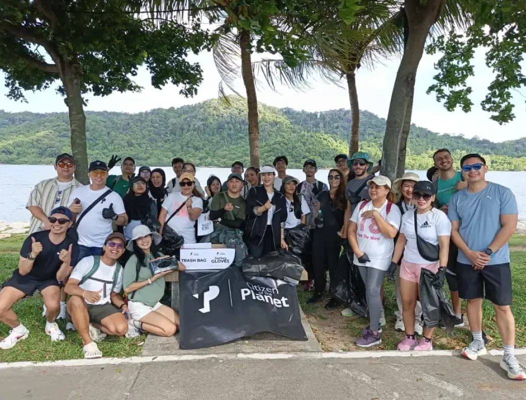 TP volunteers participating in a community cleanup near a lakeside park.