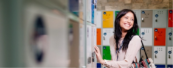 Woman smiling while opening a locker in a modern office space.